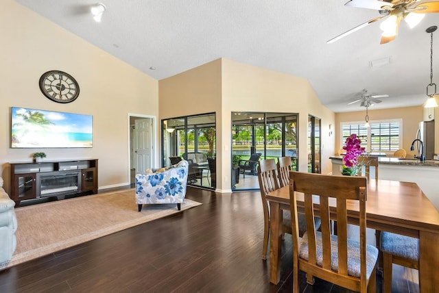 dining room featuring ceiling fan, dark wood finished floors, high vaulted ceiling, and baseboards
