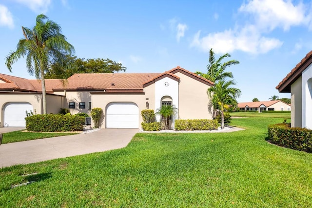 mediterranean / spanish house featuring a tiled roof, a garage, stucco siding, a front yard, and concrete driveway