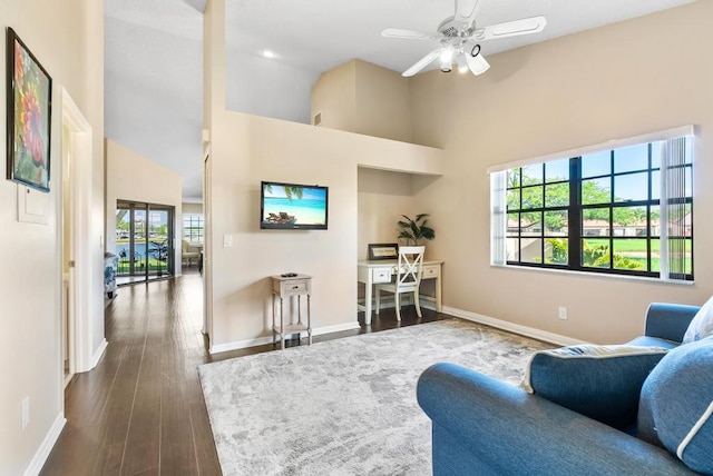 living area with baseboards, high vaulted ceiling, a ceiling fan, and dark wood-style floors
