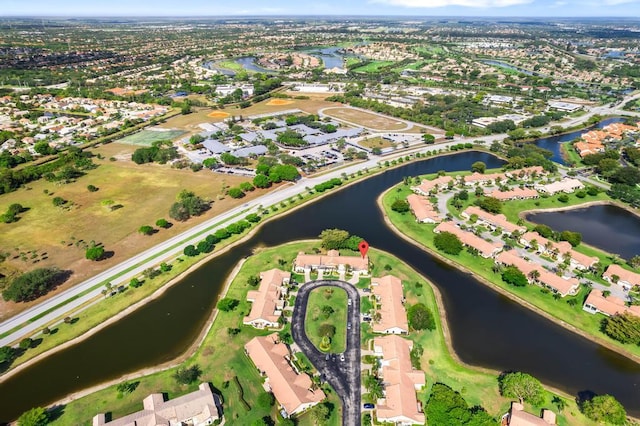 aerial view of property and surrounding area featuring a nearby body of water and nearby suburban area
