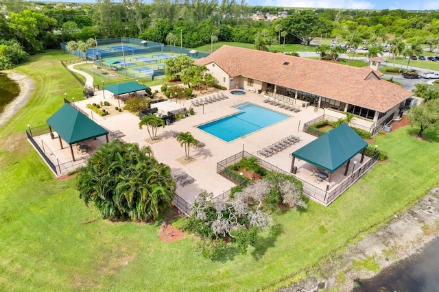 aerial view of a pool area and a tree filled landscape