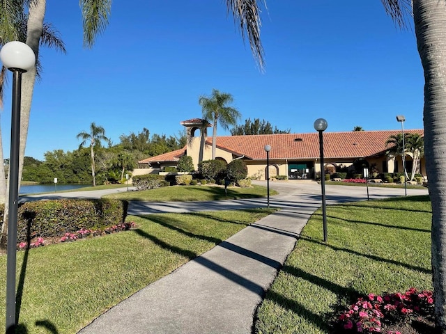 surrounding community with a yard and a water view