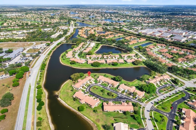 aerial view of property and surrounding area featuring a large body of water and nearby suburban area