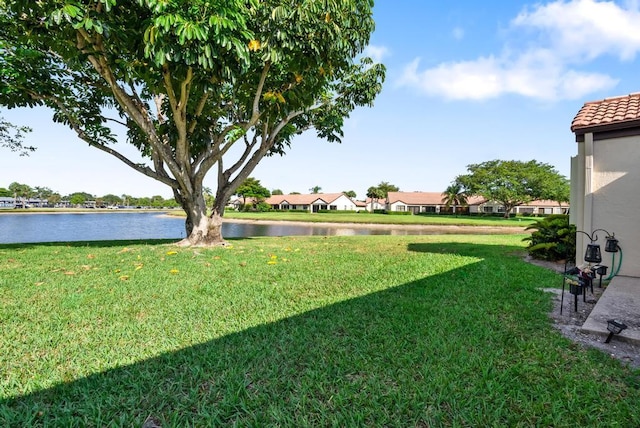 view of green lawn with a water view