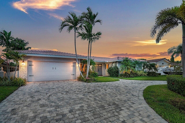 1467 NE 57th Ct, Fort Lauderdale, FL 33334 - view of front of house featuring decorative driveway, a tile roof, and an attached garage