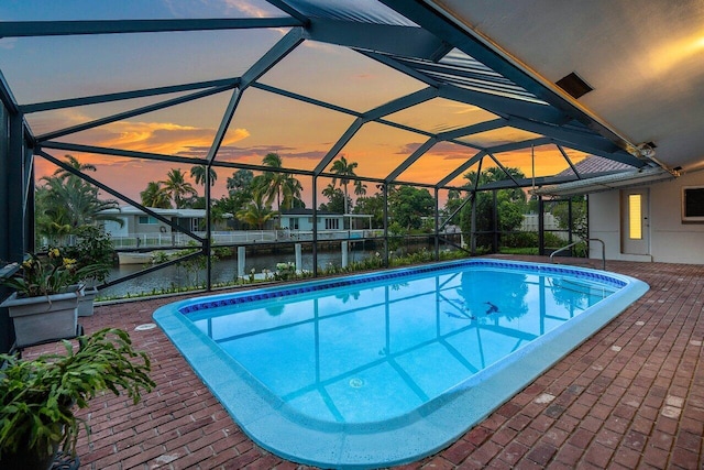 1467 NE 57th Ct, Fort Lauderdale, FL 33334 - pool at dusk featuring a water view, an outdoor pool, glass enclosure, and a patio
