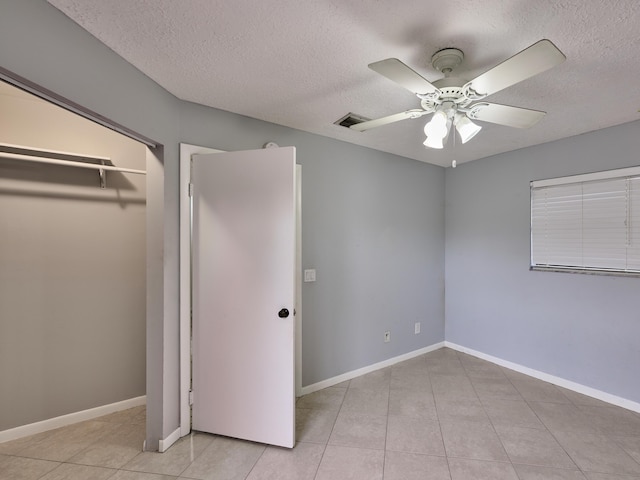 151 Meadows Dr, Boynton Beach, FL 33436 - unfurnished bedroom with a textured ceiling, light tile patterned flooring, ceiling fan, and baseboards