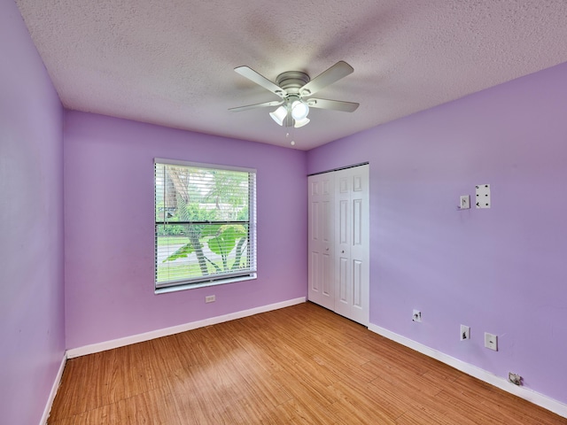 151 Meadows Dr, Boynton Beach, FL 33436 - unfurnished bedroom featuring a textured ceiling, baseboards, light wood-style floors, and a closet