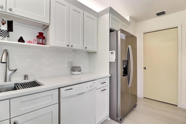 5218 Fountains Dr S Unit 206, Lake Worth, FL 33467 - kitchen with stainless steel refrigerator with ice dispenser, white dishwasher, decorative backsplash, light wood-style floors, and light countertops