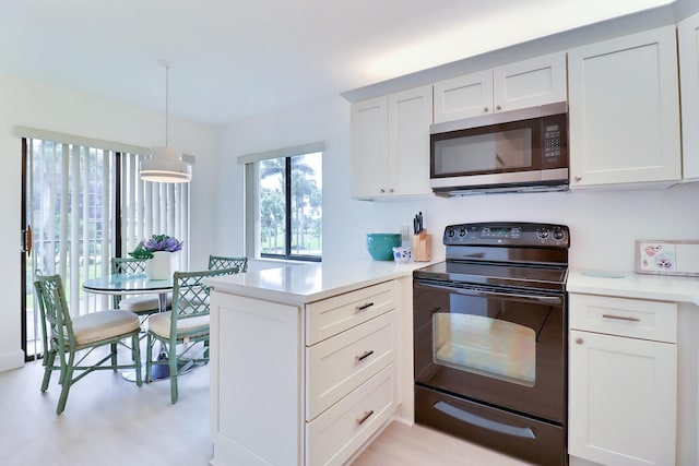 5218 Fountains Dr S Unit 206, Lake Worth, FL 33467 - kitchen with black electric range oven, stainless steel microwave, a peninsula, and light countertops
