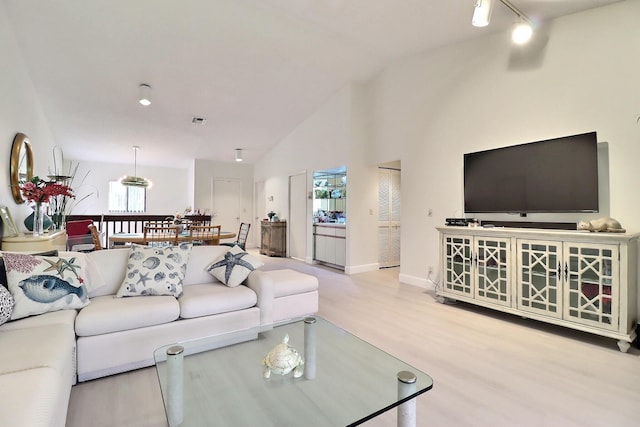5218 Fountains Dr S Unit 206, Lake Worth, FL 33467 - living area featuring lofted ceiling, wood finished floors, plenty of natural light, baseboards, and track lighting