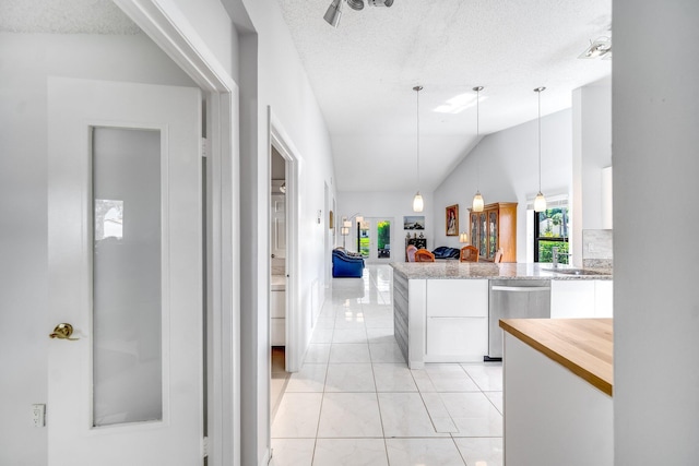 8735 Boca Glades Blvd W Unit D, Boca Raton, FL 33434 - kitchen with stainless steel dishwasher, white cabinetry, healthy amount of natural light, a textured ceiling, and pendant lighting