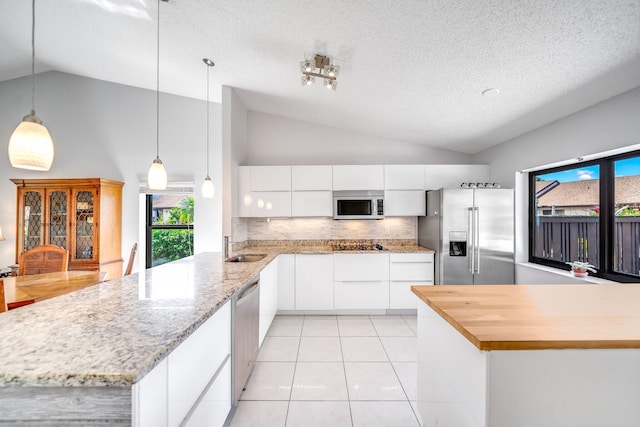8735 Boca Glades Blvd W Unit D, Boca Raton, FL 33434 - kitchen with stainless steel appliances, a peninsula, modern cabinets, white cabinetry, and high vaulted ceiling