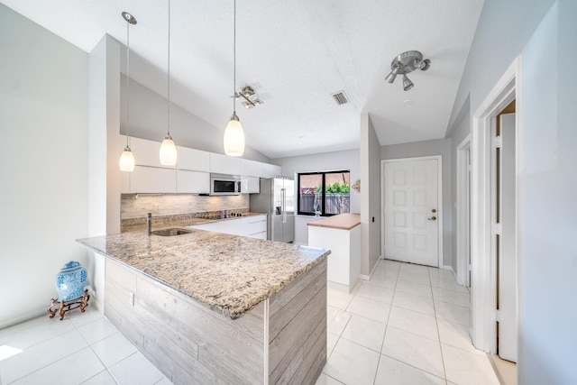 8735 Boca Glades Blvd W Unit D, Boca Raton, FL 33434 - kitchen with stainless steel appliances, backsplash, a peninsula, white cabinets, and vaulted ceiling