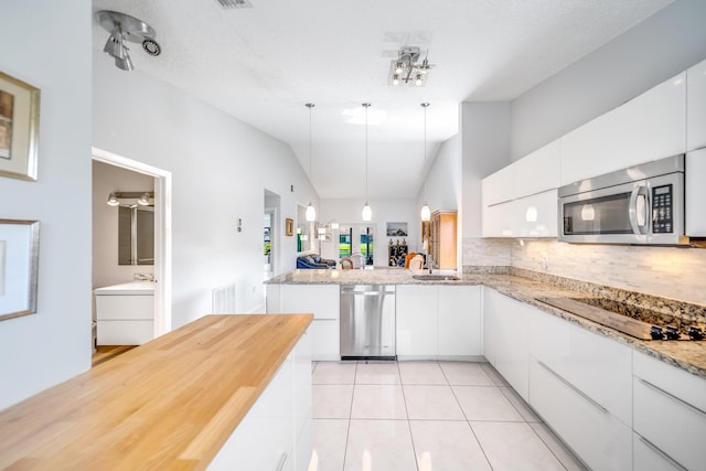 8735 Boca Glades Blvd W Unit D, Boca Raton, FL 33434 - kitchen featuring appliances with stainless steel finishes, a sink, white cabinetry, tasteful backsplash, and lofted ceiling