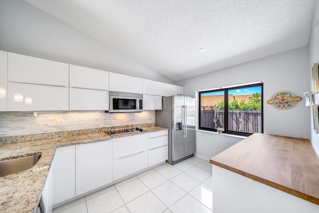 8735 Boca Glades Blvd W Unit D, Boca Raton, FL 33434 - kitchen with appliances with stainless steel finishes, a textured ceiling, tasteful backsplash, lofted ceiling, and white cabinets