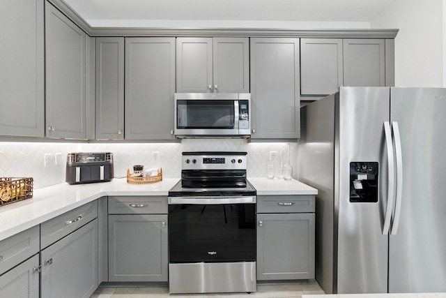 622 Parsons Way, Deerfield Beach, FL 33442 - kitchen with stainless steel appliances, gray cabinets, and decorative backsplash