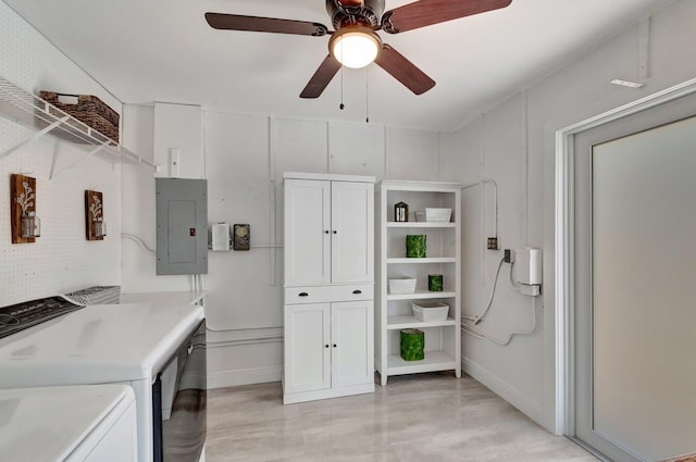 laundry area with electric panel, washing machine and dryer, a ceiling fan, baseboards, and cabinet space