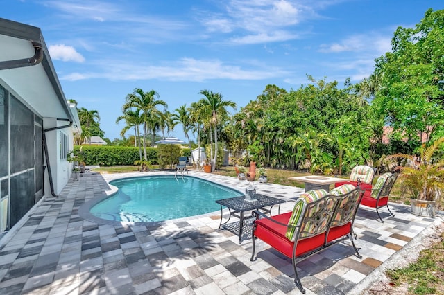 view of swimming pool featuring a patio and a storage unit