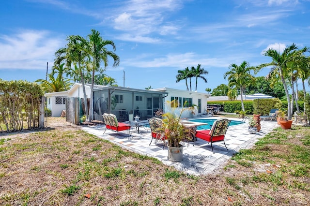 rear view of property featuring a patio, a sunroom, and fence