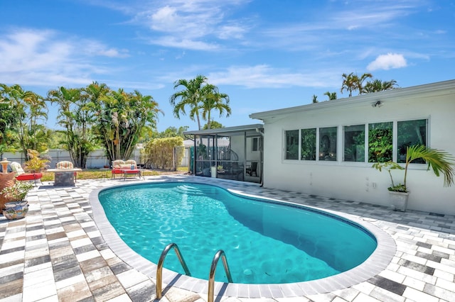 view of swimming pool with a sunroom, a patio area, and a fenced backyard