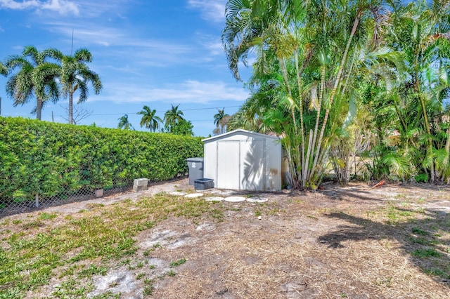 view of yard with a shed, an outdoor structure, and fence