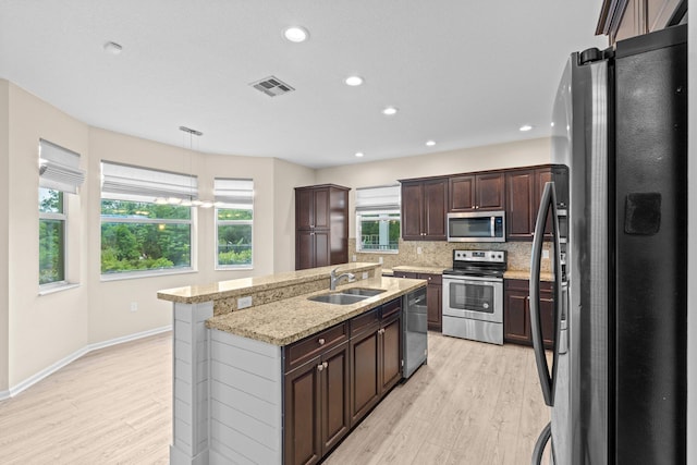 9226 Dupont Pl, Wellington, FL 33414 - kitchen with stainless steel appliances, a sink, light wood-style flooring, a center island with sink, and recessed lighting