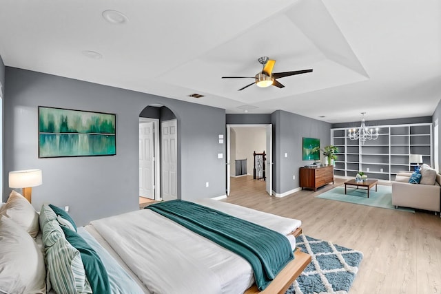 9226 Dupont Pl, Wellington, FL 33414 - bedroom featuring light wood-style flooring, arched walkways, a chandelier, and ceiling fan