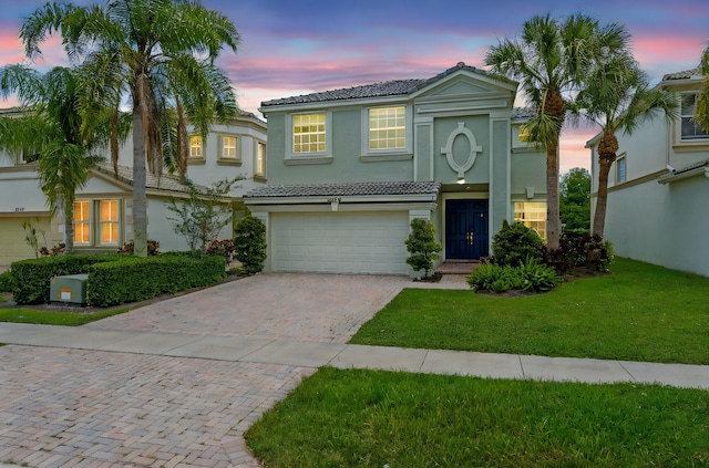 9226 Dupont Pl, Wellington, FL 33414 - view of front of home featuring a tiled roof, stucco siding, a garage, decorative driveway, and a front lawn