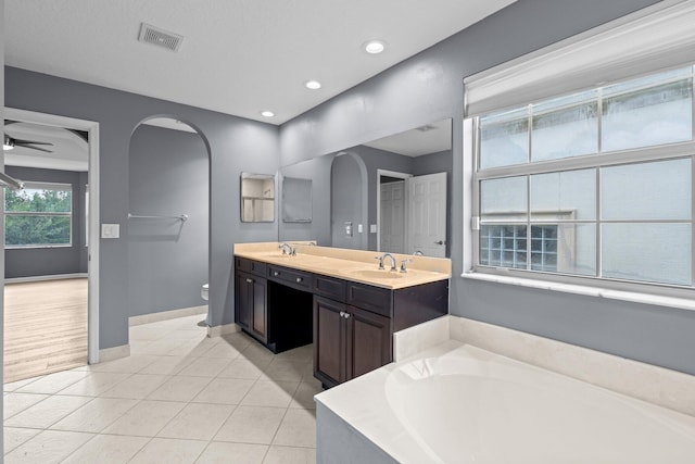9226 Dupont Pl, Wellington, FL 33414 - bathroom featuring double vanity, a bath, toilet, baseboards, and tile patterned floors