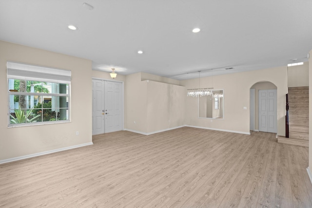 9226 Dupont Pl, Wellington, FL 33414 - unfurnished living room with light wood-style floors, baseboards, arched walkways, and recessed lighting