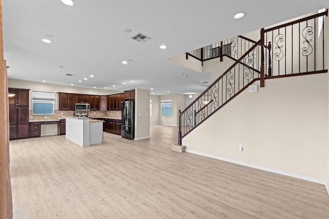 9226 Dupont Pl, Wellington, FL 33414 - kitchen with appliances with stainless steel finishes, open floor plan, baseboards, light wood-style floors, and tasteful backsplash