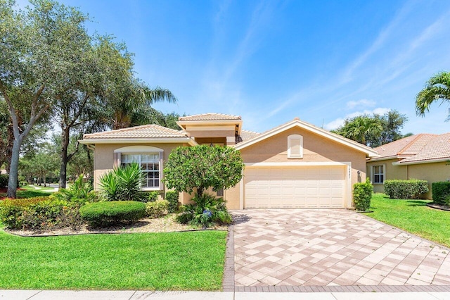 10887 Summerville Way, Boynton Beach, FL 33437 - mediterranean / spanish house with stucco siding, decorative driveway, an attached garage, a front yard, and a tiled roof