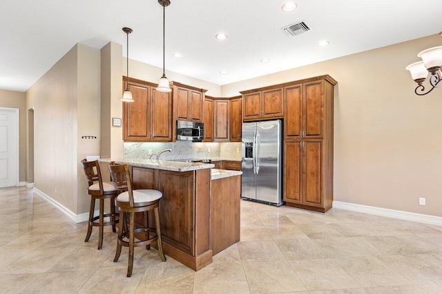 10887 Summerville Way, Boynton Beach, FL 33437 - kitchen featuring stainless steel appliances, brown cabinetry, a peninsula, baseboards, and recessed lighting