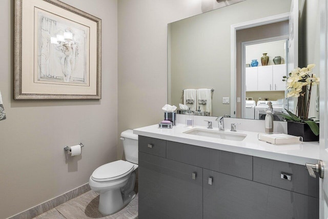 9037 Golden Mountain Cir, Boynton Beach, FL 33473 - bathroom with washing machine and dryer, toilet, vanity, and baseboards