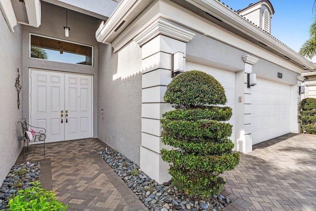9037 Golden Mountain Cir, Boynton Beach, FL 33473 - property entrance with an attached garage, decorative driveway, and stucco siding