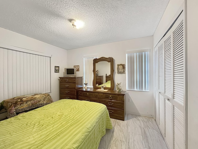 13824 SW 156th St, Miami, FL 33177 - bedroom featuring a textured ceiling, light marble finish flooring, and a closet