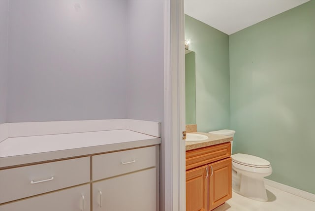 bathroom with vanity, toilet, and baseboards