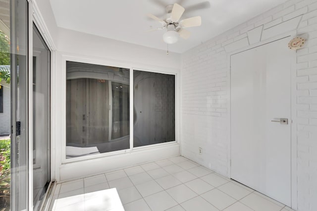 10095 45th Ter S Unit 443, Boynton Beach, FL 33436 - unfurnished room with light tile patterned floors, a ceiling fan, and brick wall