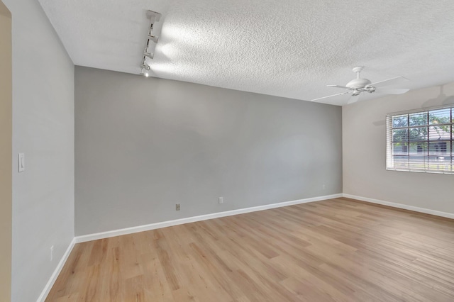 10095 45th Ter S Unit 443, Boynton Beach, FL 33436 - spare room featuring rail lighting, a textured ceiling, light wood-style flooring, a ceiling fan, and baseboards