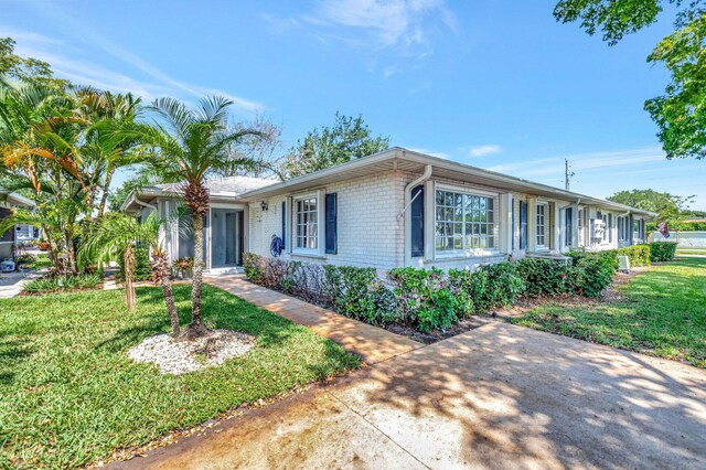 10095 45th Ter S Unit 443, Boynton Beach, FL 33436 - ranch-style house featuring brick siding and a front yard