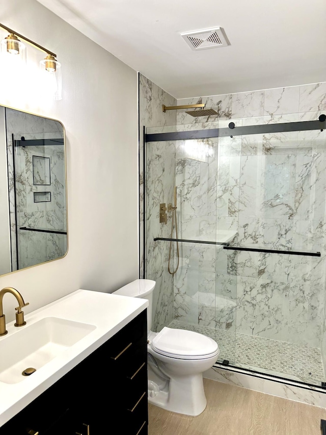 bathroom featuring a marble finish shower, toilet, vanity, and a baseboard radiator