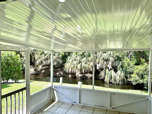 unfurnished sunroom with a water view