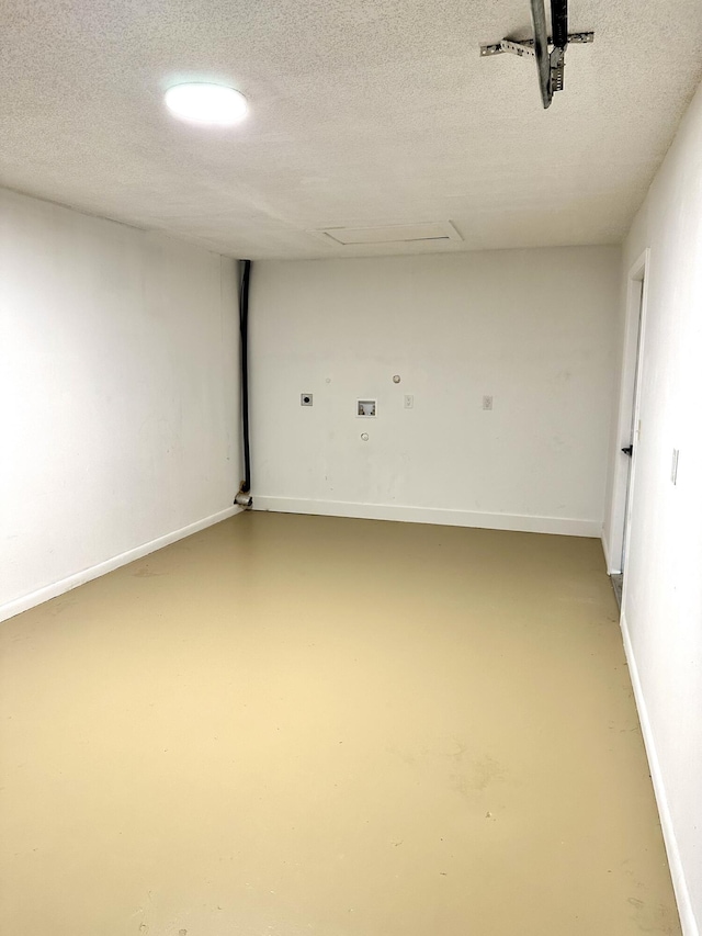 spare room with finished concrete flooring, baseboards, and a textured ceiling