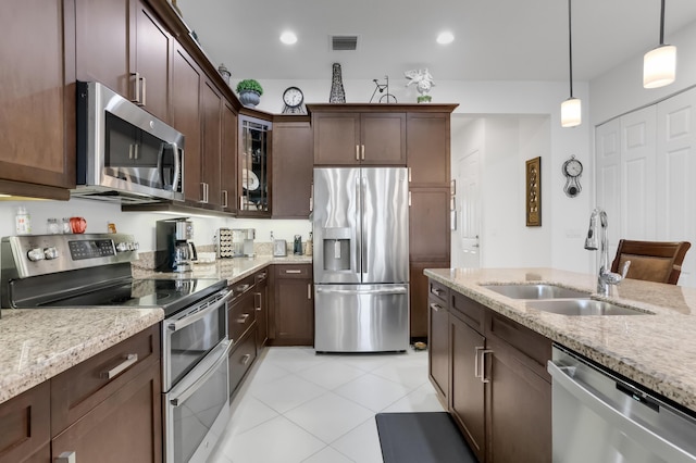 7779 Butera Plz, Delray Beach, FL 33446 - kitchen featuring appliances with stainless steel finishes, a sink, light stone countertops, hanging light fixtures, and recessed lighting