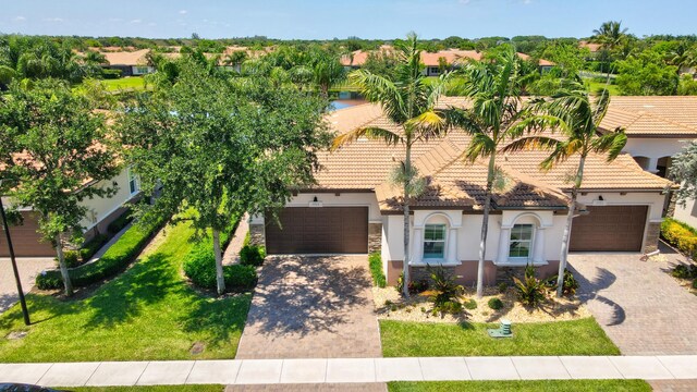 7779 Butera Plz, Delray Beach, FL 33446 - view of front facade featuring decorative driveway, stucco siding, a garage, and stone siding