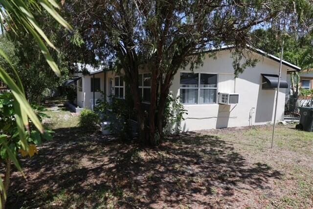1454 NE 2nd Ct, Boca Raton, FL 33432 - view of property exterior featuring stucco siding and cooling unit