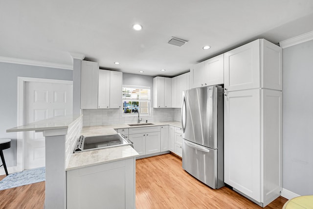 4585 NW 3rd St Unit D, Delray Beach, FL 33445 - kitchen with freestanding refrigerator, a sink, a peninsula, ornamental molding, and light countertops