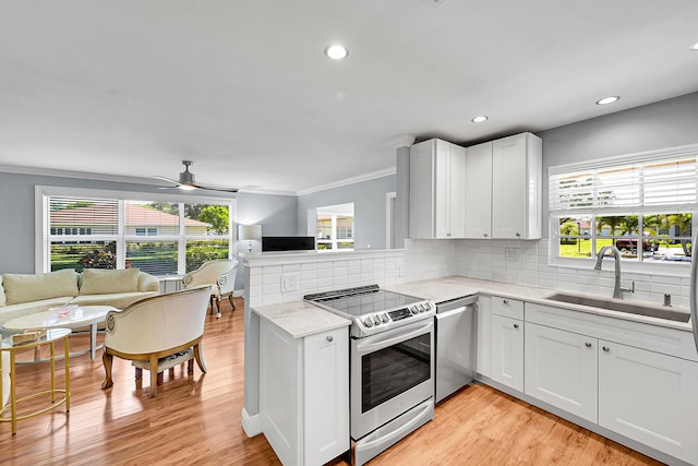 4585 NW 3rd St Unit D, Delray Beach, FL 33445 - kitchen with stainless steel appliances, a sink, open floor plan, crown molding, and ceiling fan