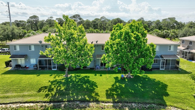 2556 Marshfield Ct, Port Saint Lucie, FL 34953 - back of house featuring a sunroom, a tiled roof, a yard, and stucco siding